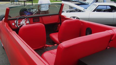 2007 Ford Mustang - A custom red convertible is displayed at an outdoor car show, with other vehicles visible in the background.