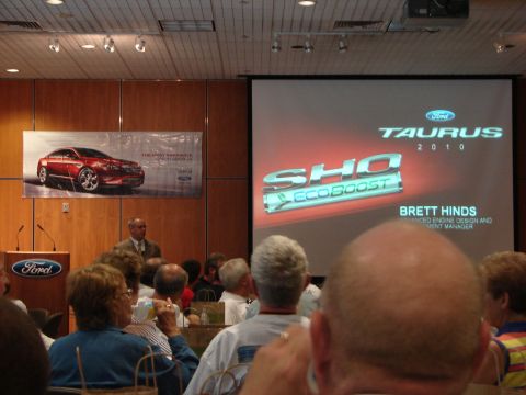 1992 Ford Taurus - A presentation about the 2010 Ford Taurus SHO EcoBoost is displayed on a large screen to an audience.
