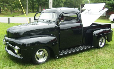 2007 Ford Mustang - A classic black pickup truck is parked on a grassy field.