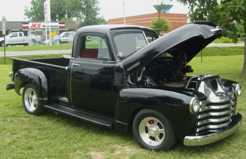 2007 Ford Mustang - This classic black Chevrolet pickup truck, likely from the early 1950s, is displayed with its hood open, revealing the engine compartment.