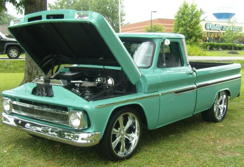 2007 Ford Mustang - A teal 1960 Chevrolet C10 pickup truck is displayed with its hood open, revealing the engine bay.