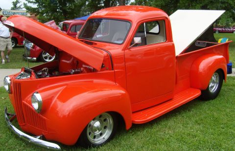 2007 Ford Mustang - Customized orange pickup truck on display at an outdoor event.