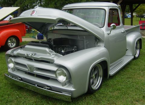 2007 Ford Mustang - A customized silver Ford pickup truck is displayed with its hood open, revealing the engine compartment.