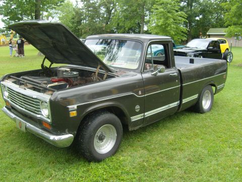 2007 Ford Mustang - An older model International pickup truck is displayed with its hood open on a grassy field.
