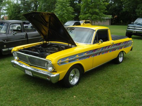 2007 Ford Mustang - A customized yellow pickup truck with flame decals and a checkered flag design is displayed with its hood open.