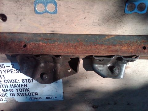1978 Ford Bronco - Close-up of a rusted metal frame section with attached brackets, with a label indicating it was made in Sweden.
