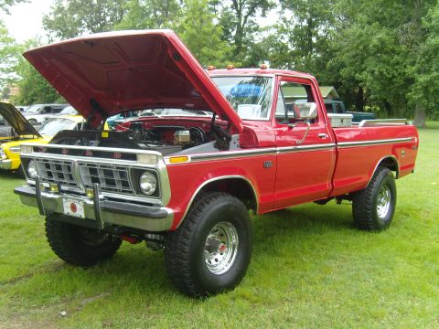 2007 Ford Mustang - A red pickup truck is displayed with its hood open at an outdoor event.