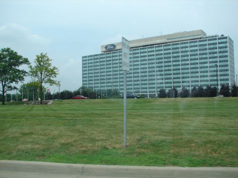 1992 Ford Taurus - A red sedan is visible in front of the Ford Motor Company headquarters building.