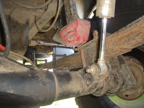 1989 Ford Bronco - This image shows the undercarriage of a vehicle, focusing on the suspension system with leaf springs and a shock absorber.
