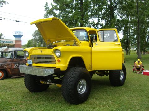 2007 Ford Mustang - This bright yellow pickup truck, likely a 1955 model, is on display with its hood and driver's door open.