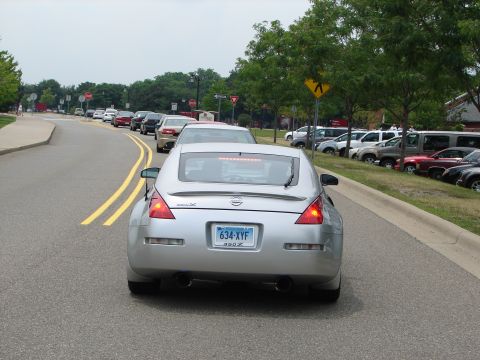 1992 Ford Taurus - A silver Nissan 350Z is seen from behind in a line of traffic on a cloudy day.