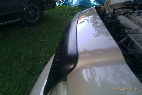 2000 Mercury Grand Marquis - Close-up of a 2000 Mercury Grand Marquis fender and engine compartment, with another vehicle visible in the background.
