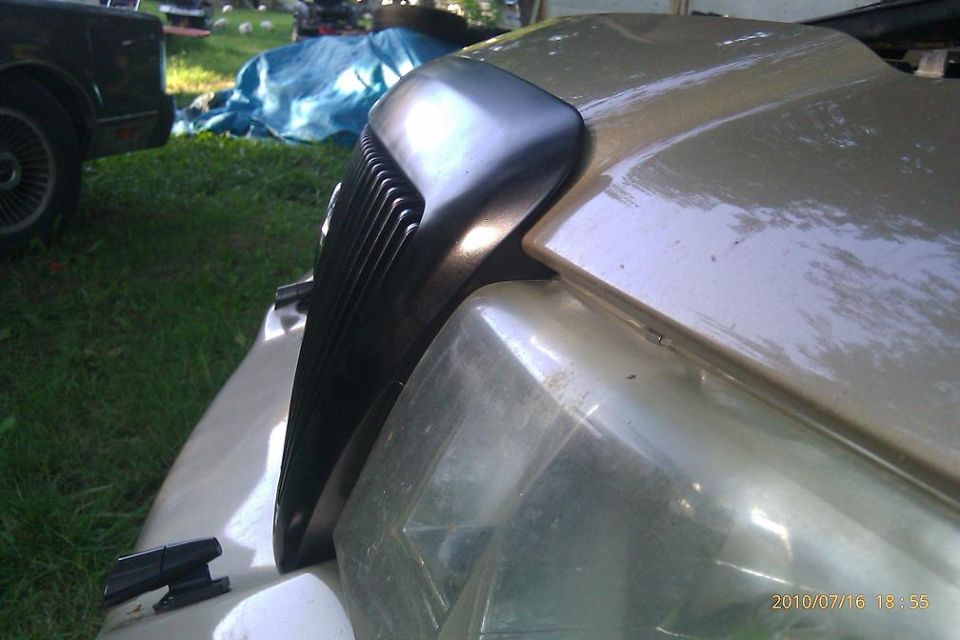 Gold 2000 Mercury Grand Marquis grille and headlight assembly, close-up front view