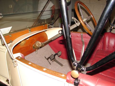 1992 Ford Taurus - The interior of a vintage automobile features red upholstery, a wooden steering wheel, and exposed mechanical components.