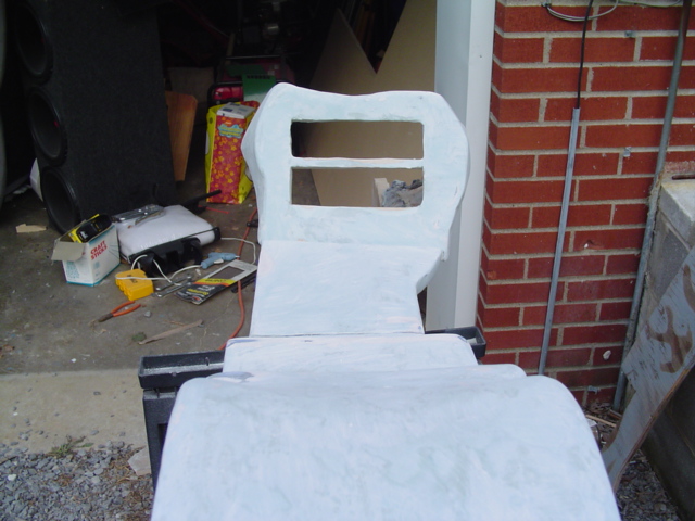 White fiberglass mold for a car seat with two rectangular openings at the top