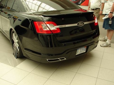 1992 Ford Taurus - Rear view of a black Ford sedan with a spoiler and dual exhaust pipes, displaying a Michigan license plate.