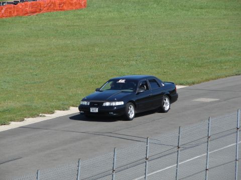 1992 Ford Taurus - A black 1992 Ford Taurus is seen on a race track with a number 66 sticker on the windshield.