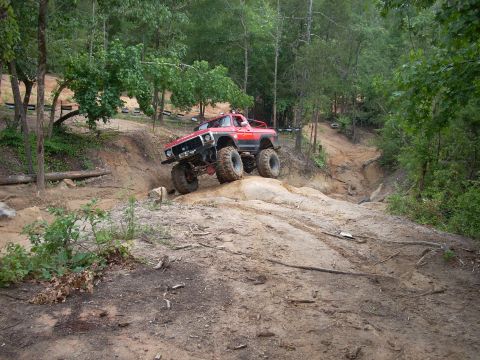 1979 Ford Bronco - This heavily modified 1979 Ford Bronco navigates a challenging off-road trail, its impressive suspension and tire grip.