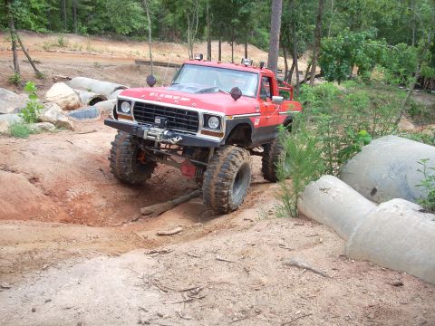 1979 Ford Bronco - This modified 1979 Ford Bronco tackles a challenging off-road trail with its lifted suspension and oversized tires.
