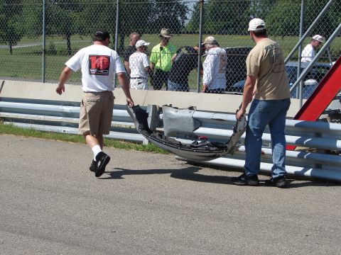 1992 Ford Taurus - Damaged car bumper being removed from a trackside guardrail.