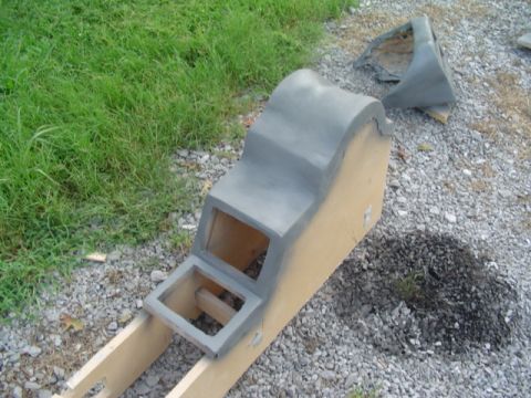 1999 Ford Taurus - A disassembled center console part is shown outdoors, covered in gray primer and supported by a wooden frame.