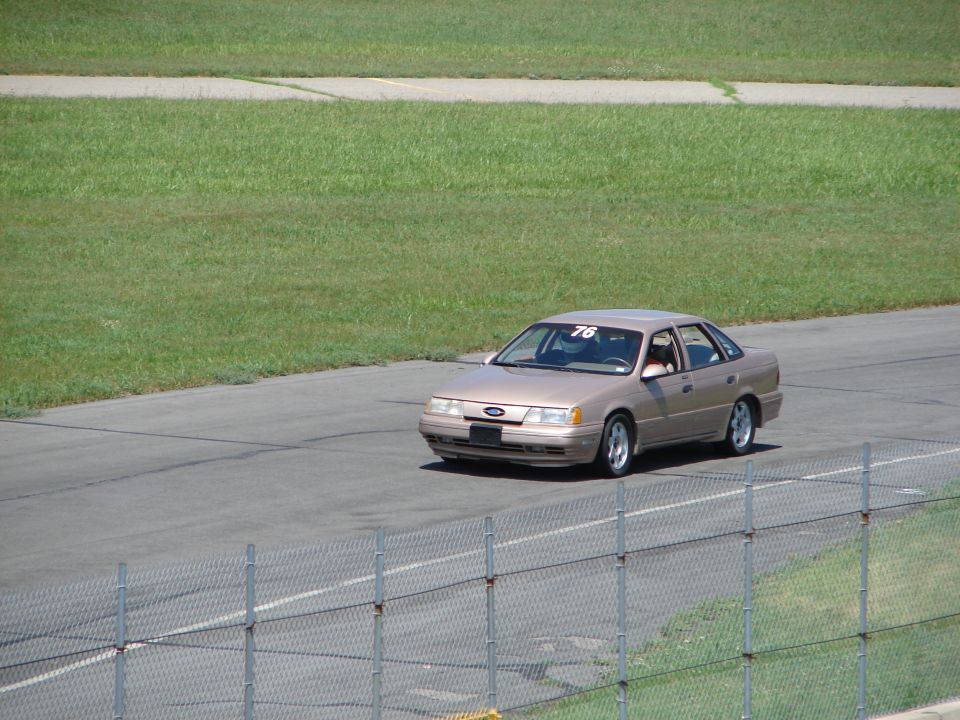 Tan 1992 Ford Taurus on racetrack with number 76 on windshield