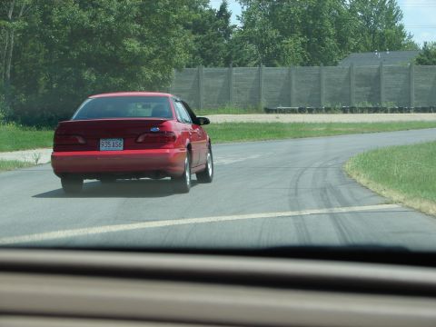 1992 Ford Taurus - A red 1992 Ford Taurus sedan is seen driving on a road.