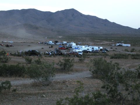 1986 Ford Bronco - A desert landscape dotted with RVs and vehicles suggests a gathering or event in a remote area.