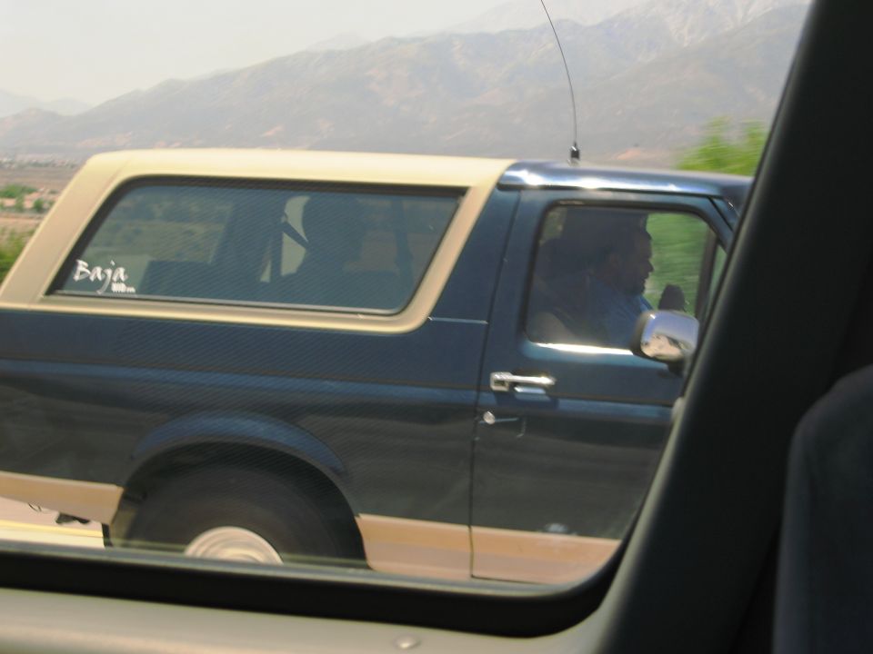 Side view of a 1986 Ford Bronco with a tan top and "Baja" sticker
