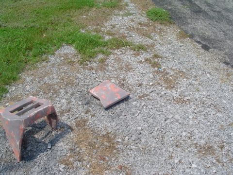 1999 Ford Taurus - Two jack stands are visible on a gravel surface next to a grassy area.