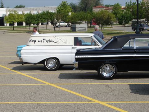 1992 Ford Taurus - Two classic vehicles, a panel van and a convertible, are parked side-by-side in a parking lot.