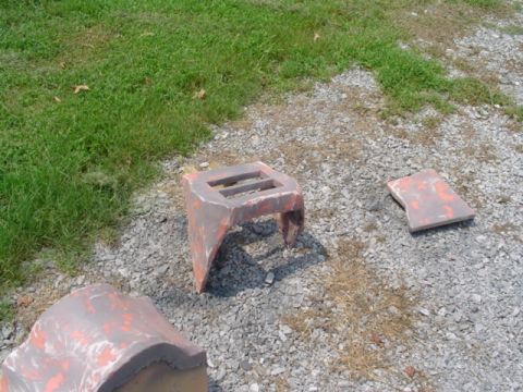 1999 Ford Taurus - Several unidentifiable automotive parts are scattered on a gravel and grass surface.