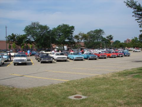 1992 Ford Taurus - A variety of classic automobiles are gathered in a parking lot under a clear blue sky.