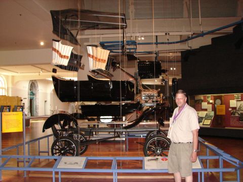 1992 Ford Taurus - An antique automobile with a canopy is suspended and displayed in a museum setting.