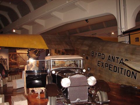 1992 Ford Taurus - A vintage automobile is displayed in front of a historic aircraft, likely part of a museum exhibit.