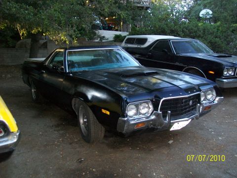 1972 Ford Ranchero - Black 1972 Ford Ranchero with a hood scoop and chrome bumper sits in a driveway.