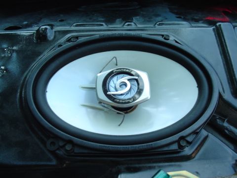 1999 Ford Taurus - Overhead close-up of a Pioneer 6x9 coaxial speaker with a white cone and chrome center tweeter bridge, dropped into the black rear deck ope…