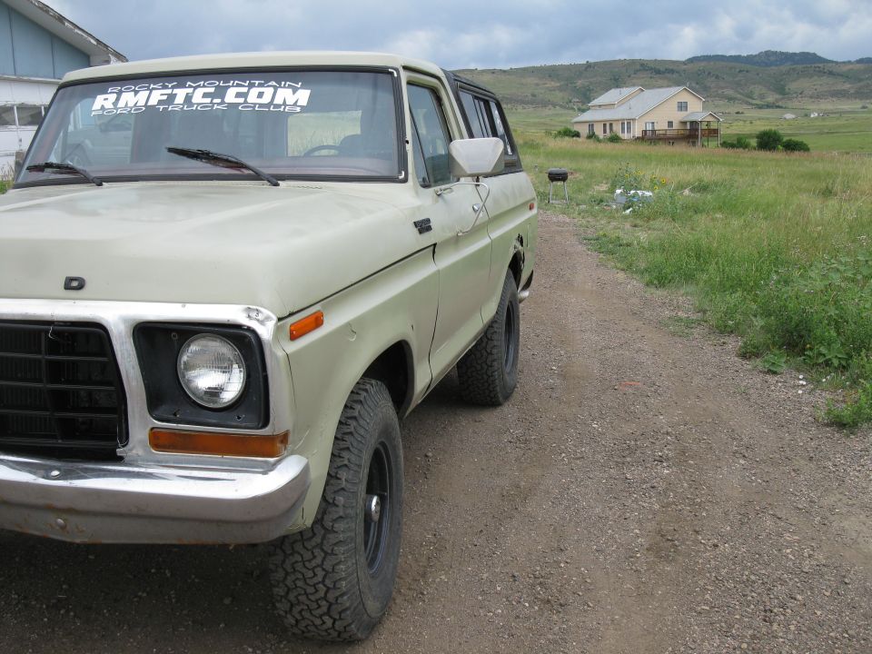 Light green 1978 Ford Bronco parked on a dirt road, front quarter view