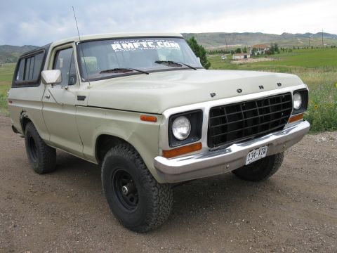 1978 Ford Bronco - A tan 1978 Ford Bronco is shown from the front three-quarter view, parked outdoors on a dirt surface.