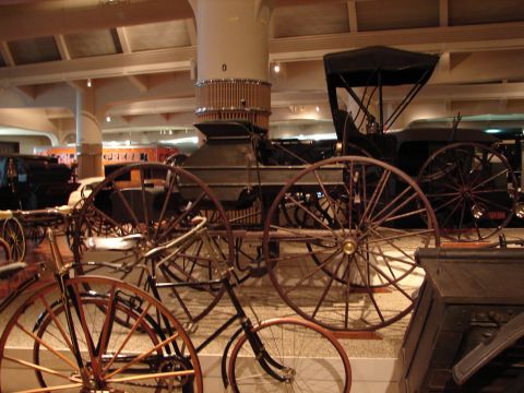 1992 Ford Taurus - A museum exhibit showcases early transportation, including a large horseless carriage and various bicycles from different eras.