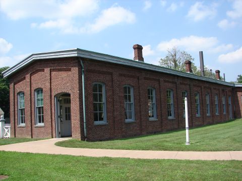1992 Ford Taurus - Exterior view of a historic brick building with a paved walkway and grassy lawn.