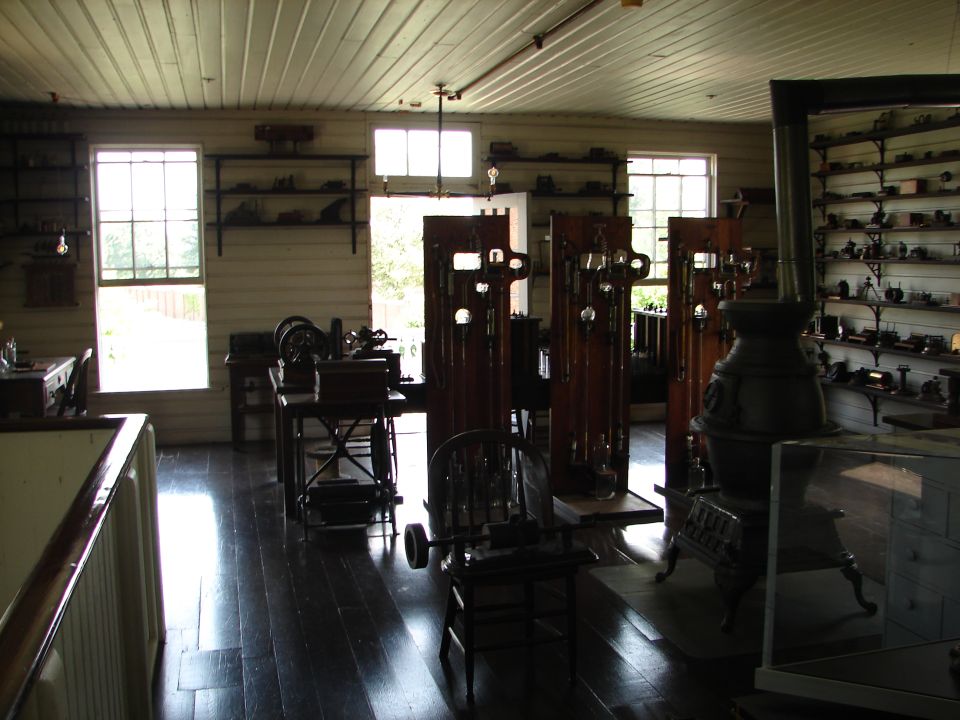 Interior of a room with display cases and antique machinery, possibly a museum