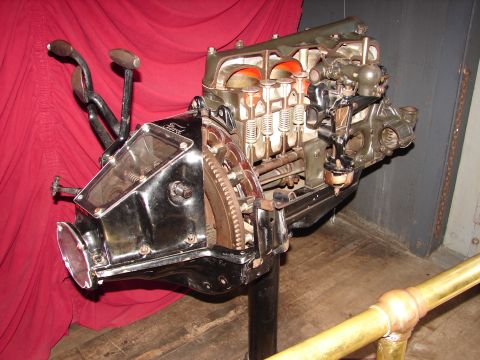 1992 Ford Taurus - A cutaway view of a Ford engine, likely from a Model T, is displayed on a stand against a red backdrop.