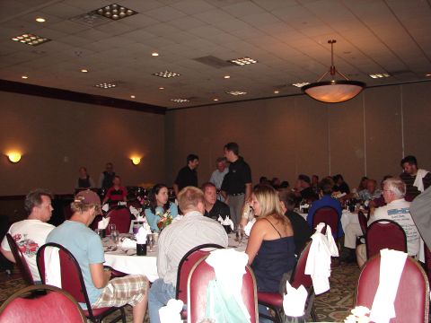 1992 Ford Taurus - A group of people are seated at tables in a large room, possibly at an event or conference.