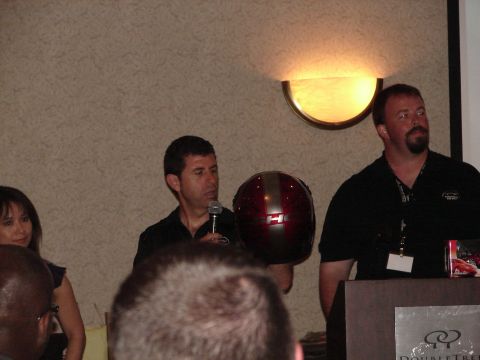 1992 Ford Taurus - Presentation attendees listen as a speaker holds up a helmet with a prominent 'H' logo.