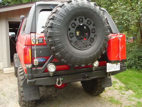 1989 Ford Bronco - This red Ford Bronco features a custom rear bumper with a spare tire mount and two red jerry cans.