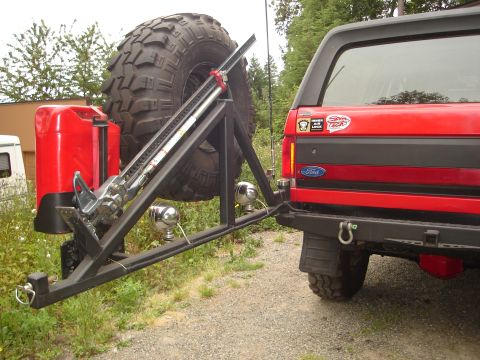 1989 Ford Bronco - Rear view of a red 1989 Ford Bronco, equipped with a custom spare tire carrier, jerry can, and hi-lift jack.