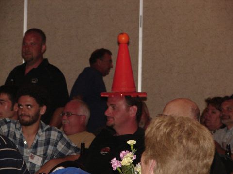 1992 Ford Taurus - A group of people are gathered indoors, with one man humorously wearing a traffic cone as a hat.