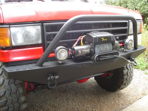 1989 Ford Bronco - This vehicle features an aftermarket bumper with a winch and auxiliary lights.