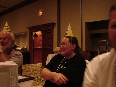 1992 Ford Taurus - Attendees at an event wear novelty party hats, with an exit sign visible in the background.